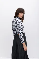 Polera de cuello alto con estampado geométrico en blanco, negro y gris.