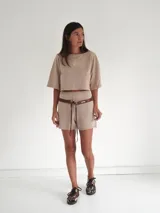 Short de punto color beige, tiro medio, con cintura elastizada y bolsillos traseros.
