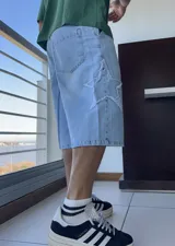 Bermuda de jean celeste, corte ancho y largo a la rodilla, con aplique de estrella en el lateral.