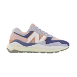 Championes urbanos New Balance modelo W5740, de mujer, con capellada de gamuza y malla en tonos lila, rosa, naranja y azul. Presentan el logo "N" característico en blanco con borde naranja y entresuela de goma blanca con suela gris.