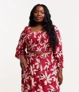 Vestido largo de viscosa con estampado floral en tonos rojos y blancos, con escote cuadrado, mangas 3/4 con elástico en los puños, corte imperio con fruncido en el busto y falda con volantes.