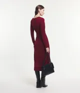 Vestido midi negro de manga larga, confeccionado en malla polyvelour, con cuello drapeado (degagê) y talle ajustado.