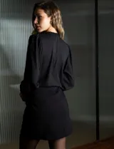 Blusa negra de gasa marca Tahari, con escote en V, apliques de botones y detalle de punto smock en hombro y puño.