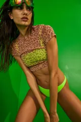 Conjunto de bikini verde neón confeccionado en lycra mate premium. El corpiño es un top con recortes y escote cuadrado, con breteles anchos. La bombacha es vedetina.