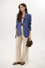 Blazer azul de lino con solapas de muesca, cierre frontal con botón y bolsillos con solapa.