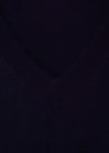 Buzo de punto fino color azul marino, con cuello en V y mangas largas. Tejido con terminaciones en canalé.