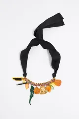 Collar con cadena dorada y cordón multicolor, con colgantes de resina con forma de hojas, calabazas y un tigre. Se ata con una cinta de tela negra.