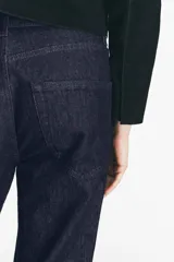 Pantalón de jean negro con corte recto, tiro medio, cinco bolsillos y detalle de banda lateral a contraste en color negro más oscuro.