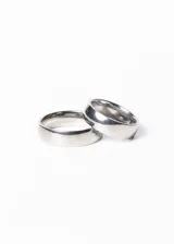 Set de dos alianzas anchas de acero quirúrgico plateado, de 6mm de ancho, con estuche de presentación.