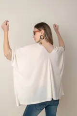 Blusa italiana color crema, tipo poncho, con escote en V con lurex, mangas 3/4 y puños ajustados.