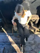 Cartera bandolera pequeña de cuero con estampado animal print, forro de tela y correa larga de cuero marrón.