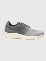 Zapatillas grises de tejido de punto con cordones, suela blanca y detalles en marrón.