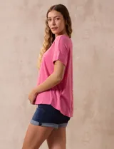Remera celeste de corte recto, con cuello redondo y mangas cortas con dobladillo. Presenta detalle de botones en la espalda.
