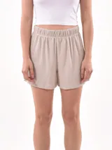 Short de tela color beige con textura acanalada y cintura elástica.