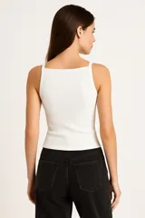 Musculosa blanca ajustada al cuerpo, de bretel fino y escote cuadrado.