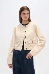 Chaqueta corta de algodón con estampado animal print en tonos grisáceos, cuello redondo, cierre frontal con botones a presión, bolsillos de parche en el pecho y corte recto.