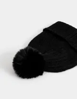 Gorro de lana tejido color negro con pompón de piel sintética en la parte superior y borde acanalado.