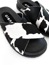 Sandalias negras con estampado de vaca, de cuero, con tiras cruzadas y suela plana.