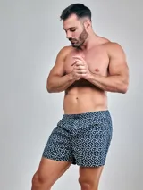 Bóxer de algodón con estampado de flores blancas sobre fondo azul marino y cintura elástica.