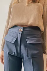 Pantalón de vestir azul con bolsillos frontales tipo cargo y botón de coco.