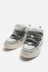 Zapatilla deportiva color beige, estilo skate. Capellada fabricada en combinación de piezas y materiales. Lengüeta acolchada. Detalle de cordones de cuerda. Tirador trasero para facilitar el calce. Suela con volumen y diseño irregular.