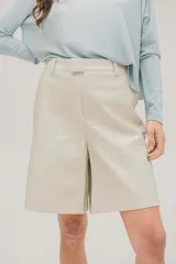 Bermuda color beige de cuerina, tiro alto, con cierre y botón invisible.