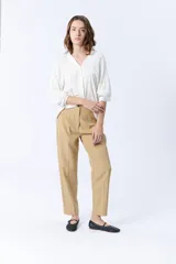 Pantalón de vestir color beige, de corte recto y tiro alto.