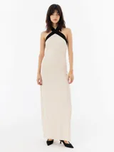 Vestido largo color crema con cuello halter cruzado en negro, confeccionado en lino.