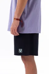 Bermuda negra de corte cómodo confeccionada en tela de jogging con logo estampado en la pierna izquierda.