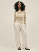 Pantalón estilo cargo color crudo, confeccionado en lino tencel. Cuenta con bolsillos laterales, elástico en la cintura y detalle de Polonio en cobre.
