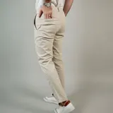 Pantalón chino color arena, corte slim fit, con bolsillos laterales y traseros.