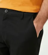 Pantalón de vestir color marrón, de corte slim y largo cropped. Confeccionado en tejido de algodón liso, con bolsillos laterales y traseros. Cierre frontal con botón y cremallera.