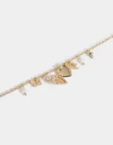 Collar corto dorado con cadena de eslabones y dijes colgantes: corazón labrado, mariposa, perlas, cuentas de cerámica con flores y moño.