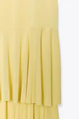 Vestido midi amarillo pálido con tirantes finos ajustables y escote en pico. Falda con tres volantes en capas.