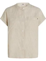 Blusa de lino a rayas verticales color beige y blanco, de corte amplio, manga corta tipo kimono, cuello mao y cierre frontal con botones. Tiene dos bolsillos de parche en el pecho y logo de Tommy Hilfiger bordado.