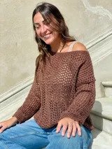 Sweater de punto calado color crema, con cuello, puños y ruedo en marrón con lurex. El cuello puede usarse de dos formas: mostrando un hombro o de forma clásica.