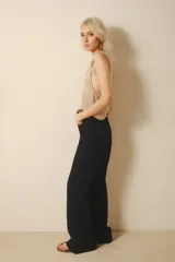 Pantalón de jean acampanado color azul oscuro, con cintura alta y bolsillos delanteros y traseros.