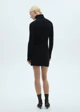 Vestido corto negro de punto con cuello alto y mangas largas.