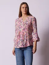 Blusa estampada con flores en tonos rosa, naranja y azul marino. Tiene escote en V con detalle de pliegues y mangas 3/4 con volados.