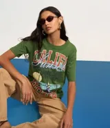 Remera verde militar de algodón con cuello redondo y mangas cortas. Estampado frontal con palmeras, olas y texto "Califa Hour".