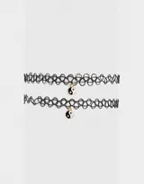 Set de dos chokers elásticos negros con dije de yin yang esmaltado.