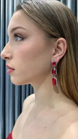 Aros colgantes plateados con tres piedras rectangulares rojas engarzadas y rodeadas de strass.