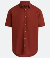 Camisa color ladrillo de lino y algodón, de corte recto, con cuello camisero, manga corta y cierre frontal con botones.