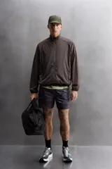 Cazadora relaxed fit confeccionada en tejido técnico ligero color marrón. Cuello subido, manga larga acabada en puño con elástico, bolsillos frontales en cadera con cierre de cremallera oculta en costura y cierre frontal con cremallera.