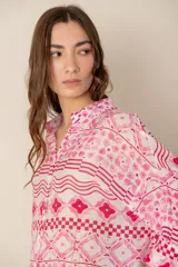 Camisa celeste con estampado de soles, lunas, flores y tortugas en tonos verdes, amarillos y naranjas.