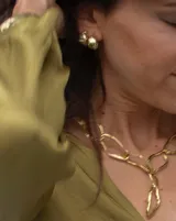 Aros pequeños de bronce con forma irregular y acabado liso, estilo huggie o argolla gruesa.