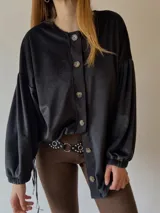 Sobrecamisa negra de plush con mangas abullonadas y cierre frontal con botones.