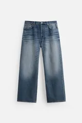 Pantalón de jean celeste con efecto lavado, corte flare fit y caída baggy desde la rodilla hasta el tobillo. Tiene cinco bolsillos y cierre frontal con botones.