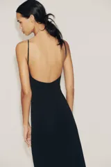 Vestido largo negro de tejido crepe, con escote en V pronunciado y tirantes finos ajustables. Presenta aberturas laterales en el bajo.