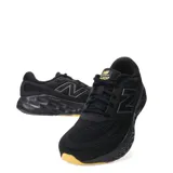 Championes de running New Balance, color negro, con detalles en gris y suela color caramelo.